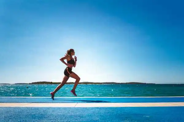 Woman running showing strong leg muscle Binton
